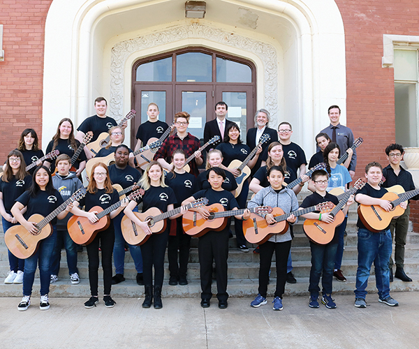 Participants in the 2023 Guitar Festival pose outside Ryerson Hall with Northwestern Reichenberger Fine Arts Department faculty members.