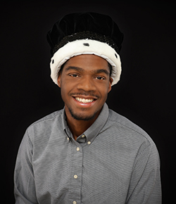 Headshot of 2025 Ranger King Tra'von Johns wearing his crown and gray shirt.