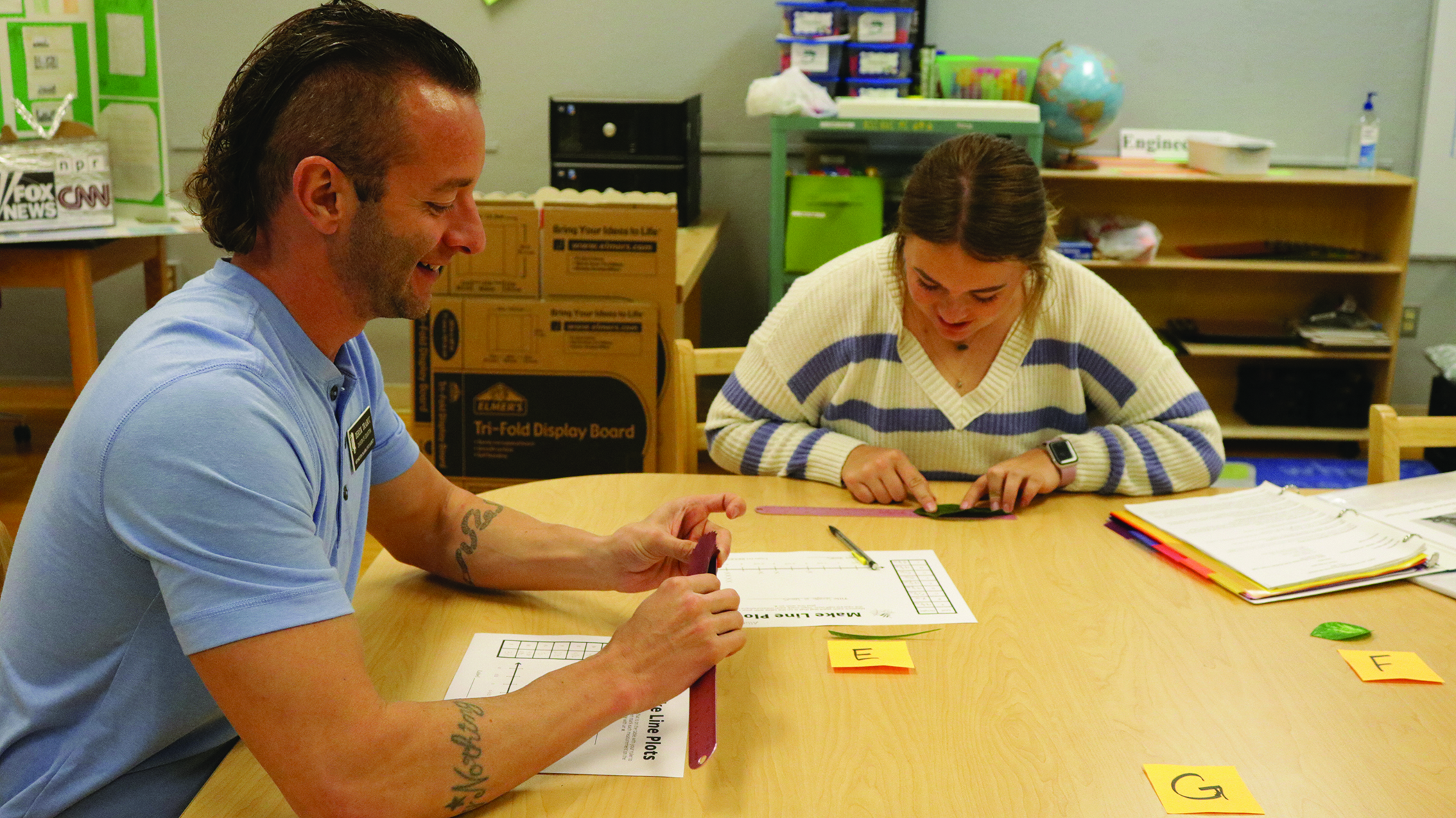 Mr. Derek Trabuc, instructor of education, guides an education student through an activity.