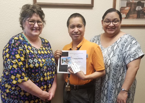 Natalie Miller (left) and Melissa Brown (right) present Adrian Ibarra with a spring Campus Kudos Award. 