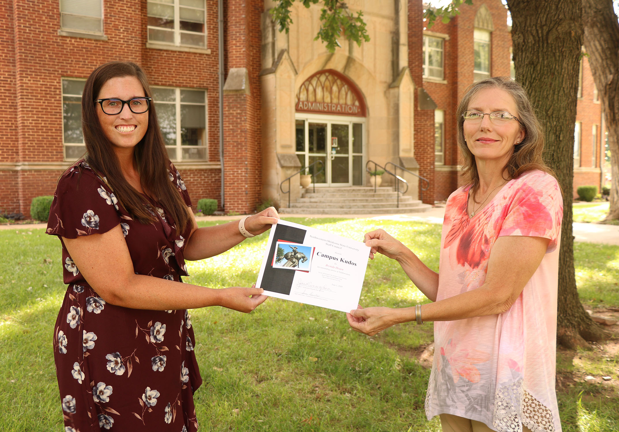 Sue Burks (right) presents Brenda Hearn with a spring Campus Kudos Award. 