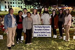 Northwestern SWAT members “fostered” two Wooden Children during The Care Campus’s 2025 Wooden Children Project. Pictured are (left to right) Maureen Torres, Mona Henos, Lorina Jibas, Anna Lara, Haylee Sellers, James Fanning, Lizbeth Lopez, Emey Lopez and Codi Harding, assistant professor of social work and SWAT sponsor.