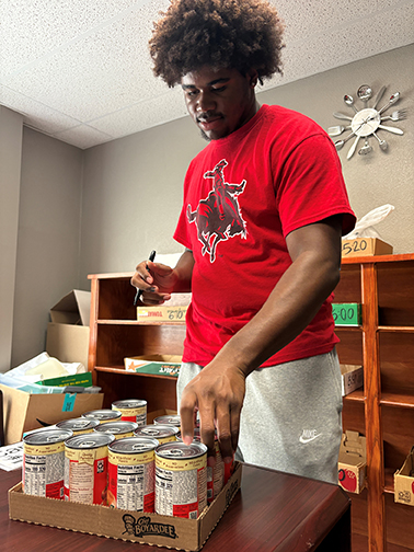Damonta Jones, a Midwest City freshman majoring in sociology, volunteers at the Northwestern Campus Cabinet Food Pantry in Alva to fulfill hours needed for a Habitudes Class.