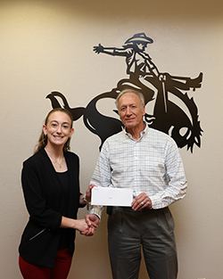 Hadley Bohlen (left), a Northwestern Oklahoma State University senior accounting major from Ringwood, receives her $2,000 scholarship award from Henry Bickerstaff (right), scholarship benefactor.