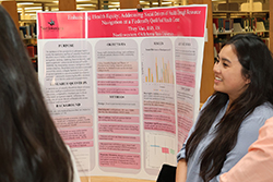 Northwestern DNP graduate Thuy Van presents her doctoral project on a research poster in the J.W. Martin Library during the 2025 residency week. The presentation is part of the program's community outreach efforts.