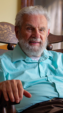 Dr. Ken Brown sits in a rocking chair at his home. Brown is the 2025 Northwestern Oklahoma State University homecoming parade marshal. (Photo Credit: Kenneth Irving, Northwestern News.)