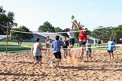 A group of Northwestern students play volleyball outside Coronado Hall during the 2024 Aloha! Northwestern event.