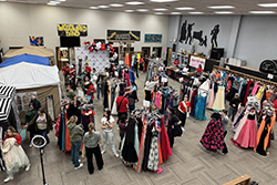 High school students and their families browse racks of colorful formal dresses at a previous Northwestern Department of Social Work Primp for Prom event.