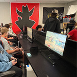 Students sitting at a row of computers competing in esports games in the NWOSU esports contest room.