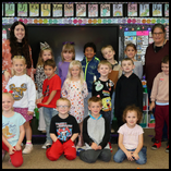Cecely Franz (back row, left) poses with her kindergarten class and paraprofessional Starlet James (back row, right) at Washington Early Childhood Center.