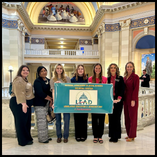 Seven members of the Northwestern Oklahoma State University Department of Social Work stand in the Oklahoma State Capitol rotunda holding a Legislative Education and Advocacy Day banner.
