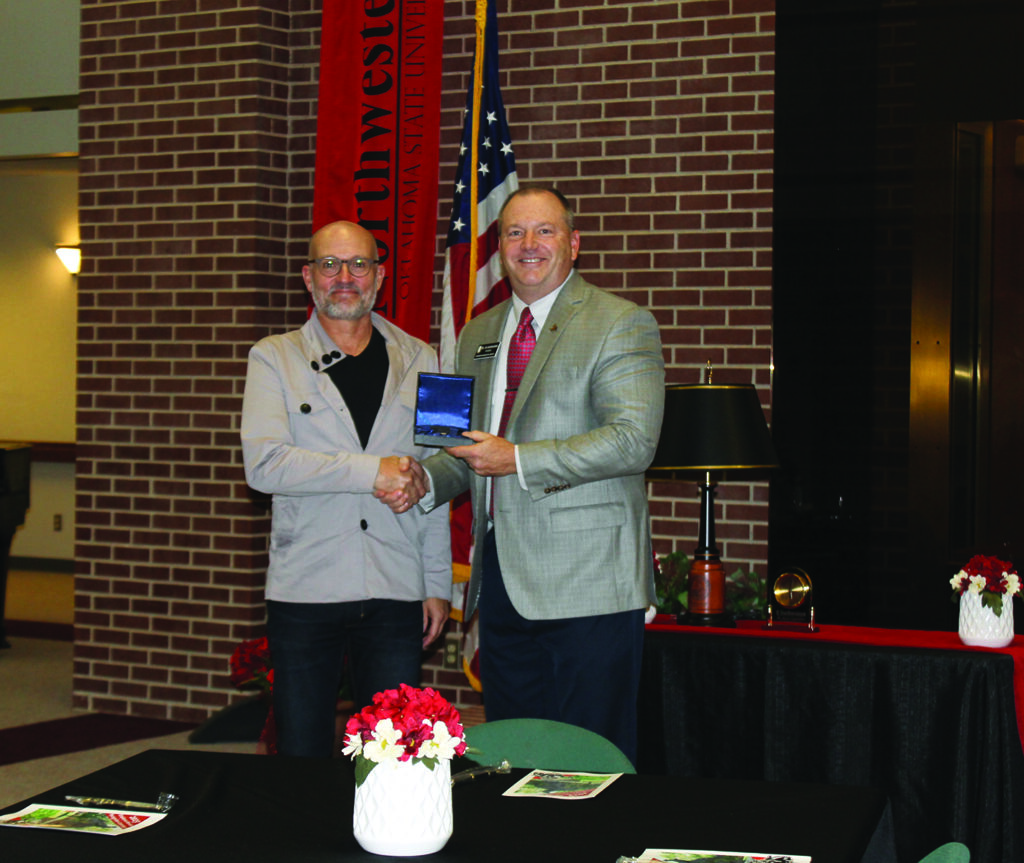 Dr. Steven Mackie shakes hands with Northwestern President Dr. Bo Hannaford after receiving his 15-year service award.