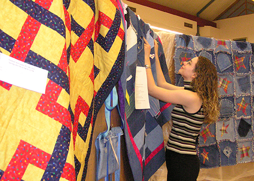 Helena Plett (now McLaurin) works with getting the quilt entries ready for the first show on pegboard displays borrowed from the Woods County Fairgrounds.