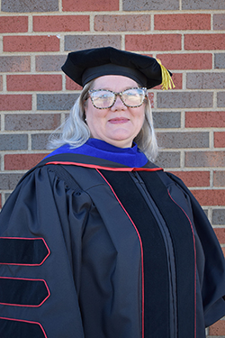 Dr. Shannon Leaper, library services director of the J.W. Martin Library and assistant professor of library and information science, in her doctoral regalia.