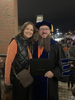 Dr. Keenan Meeker (right), assistant professor of mathematics, and his wife, Tiffany (left) pose for a photo on the Oklahoma State University campus after he received his doctoral degree in December 2023.