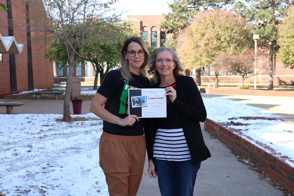 Sue Burks (right) presents Taylor Phillips with a summer Campus Kudos Award.