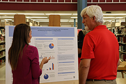 Dr. James Bell (right), vice president for academic affairs, listens to a DNP graduate’s presentation in the J.W. Martin Library during the 2024 DNP Residency Week.