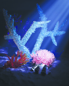 Computer-rendered artwork by Timothy Earl Neill: branching, glittering blue-and-white coral forms rise behind a smaller red coral and a pink, spiky coral cluster on a dark, sandy surface, lit by a beam of light from the upper right.