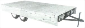 Finished trailer deck with plywood sides attached, leaving a gap between the bottom of the side and the ground.