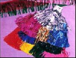 Rolls of multicolored plastic fringe in red, blue, yellow and silver.