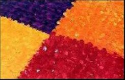 Close-up of vinyl floral sheeting in four solid color blocks — purple, orange, gold and red — with a matte, petaled surface.