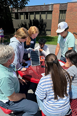 NextEra Energy employees and STEM camp students conduct a solar energy experiment at the Charles and Jane Tucker Ranger Plaza on the Northwestern-Alva campus. Pictured are: (left to right) Terry Benton (NextEra Energy); Chloe Prophet, Jasey Groves, Aryan Kadapa, Jaxon Sutton, Aanchal Regmi, and Ellie Keller.